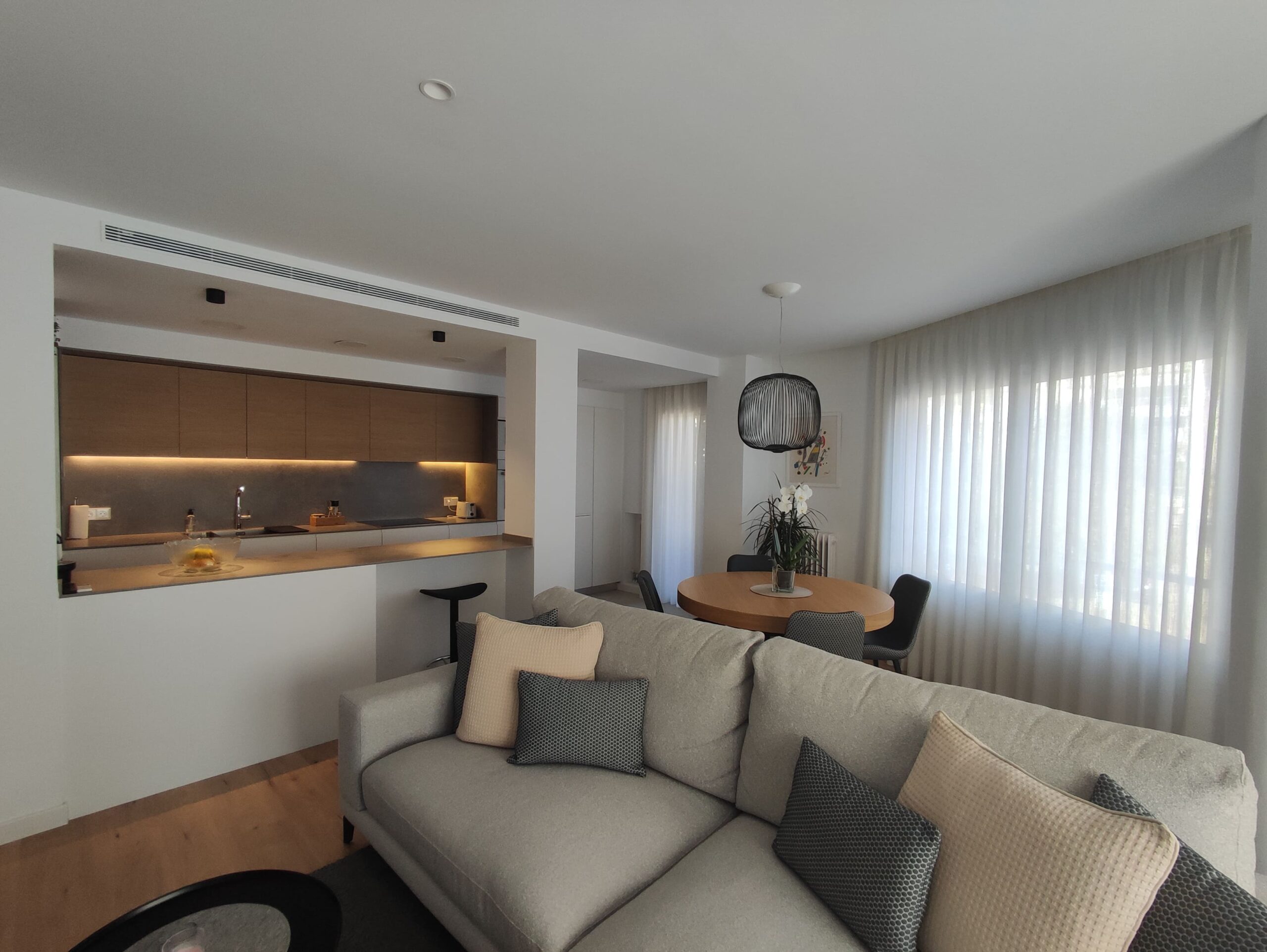 Reforma d'habitatge amb sala d'estar amb color fusta i blanc