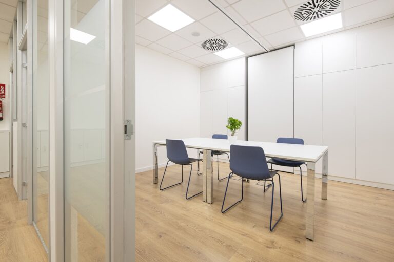 Reforma d'oficina amb blanc i fusta en una sala de reunions petita
